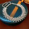 Gros plan du collier en strass étincelants au design irrégulier sur un présentoir - Argenté