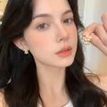 Elegant gold flower stud earrings featuring white pearls and crystals on a model - Gold Pearl Rhinestone Delicate Petal Stud Earrings