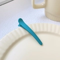 Single 8cm teal matte plastic duckbill hair clip placed on a beige ceramic plate - Lake Blue