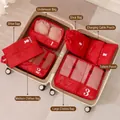Red travel luggage organizers set inside suitcase featuring multiple storage bags - Red 7-Piece Set