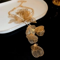 Detail of golden woven wire flower tassel on the multi-layer necklace with镂空工艺 - Gold