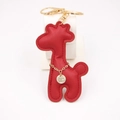Detail van rode PU-leren giraf-sleutelhanger met gouden metalen ring en decoratieve ketting - Rood