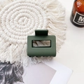 Detail of a dark green rectangular matte claw clip on a woven mat with a lifestyle backdrop - Small Matte Square Claw-Grass Green