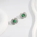 Close-up of fan-shaped silver studs with green cat eye stone and radiating texture - Green