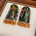 Detalle de pendientes bohemios con patrones de resina veteada multicolor y cuentas de ámbar - Poste de pendiente de plata - Colorido