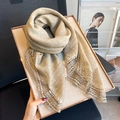 Elegante sciarpa di pizzo beige in misto cotone e lino appoggiata su un quadro d'arte - Cachi