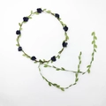 Detailed view of dark blue rose flower crown with green leaf vine on white backdrop - Black