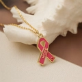 Close-up of pink enamel ribbon pendant with HOPE engraving on a gold necklace chain - Pink HOPE Ribbon