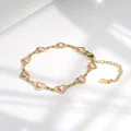 Macro-opname van hartvormige boze oog-schakels en karabijnsluiting op de gouden armband - Roze Oog