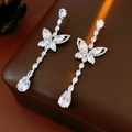 Detailed close-up of silver butterfly drop earrings with cubic zirconia on leather - White (Silver Earring Post-Silver)