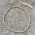 Macro di una collana di perle a due strati con ciondolo in zircone su tessuto a maglia - Signora Vintage / Collana di Perle con Zirconia a Goccia Dorata