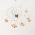 Close-up of golden Christmas wine glass charms with star, snowflake and tree pendants - Set A (Snowflake/Heart/Star/Reindeer/Clover/Tree)