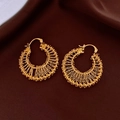 Detail of gold plated hollow woven round hoop earrings on deep red silk fabric texture - Gold