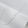 Detailed view of a sleek silver cross pendant on a minimalist double layered chain necklace - Steel Color Cross
