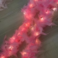 Detail of pink feather boa with glowing LED lights on a wooden floor background - Large Decorative Boa / Pink/Thick/Warm Light