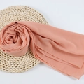 Lightweight coral orange chiffon hijab scarf draped elegantly on a woven straw mat - 107
