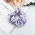 Close-up of light purple satin scrunchie with silky folds on a white aesthetic background - Purple