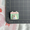 Detail of pink and green resin calendar charm for DIY accessories on a cutting mat - Calendar
