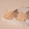 Close-up of translucent resin flower earrings with peach bead center on white stone - Pink Flower Style