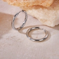 Minimalist silver hoop earrings displayed on a natural orange mineral stone base - Inner Diameter 16mm / Steel