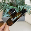 Dettaglio della trama ambra tartarugata e della finitura lucida della grande pinza per capelli - Tartarugato Lucido