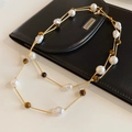Detalle de cuentas ojo de tigre y perlas barrocas en cadena de oro sobre bolso de cuero - Collar-Marrón-Blanco