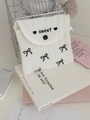 Detalle de bolsa acolchada blanca con lazo negro y bordado sweet en tela de algodón - Múltiples Lazos / Bordado Negro
