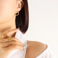 Minimalist gold-plated hexagonal earrings and rings worn by a model in a studio - Polygon / Gold