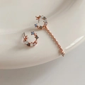 Detail van asymmetrische roségouden oorbellen met maansikkel, iriserende stenen en parels - Roségoud Halve Maan Asymmetrische Kwastjes Stijl