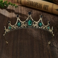 Close-up of vintage golden crown with emerald green gems on dark wooden background - Bronze Base Green Zirconia