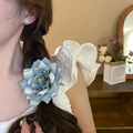 Detailed view of a gradient blue fabric rose hair clip styled on a brunette braided hairstyle - Blue Gradient Flower (Duckbill Clip)