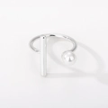 Macro shot of silver adjustable ring featuring a sleek metal bar and a white pearl detail - 449 Open Pearl Geometric / Silver