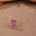 Detailed view of a gradient purple and pink resin bear pendant on a gold chain necklace - Necklace / Purple