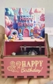 Pink wooden hand-crank music box with colorful castle illustration and Happy Birthday text - Happy Birthday 16