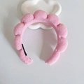 Pink plush braided headband with soft cloud design on a white decorative tray - Pink