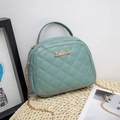 Teal quilted PU leather handbag with chain strap and top handle displayed on straw mat - Blue