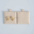 Close-up of cream floral earrings with pearls on a beige velvet jewelry display card - Beige
