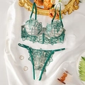 Close-up of emerald green floral embroidery lace bra and matching panty set on satin - S / Green