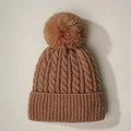 Primer plano de gorro de punto trenzado marrón con textura gruesa y pompón de piel suave - Caqui