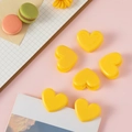 Set di sei clip in plastica gialla a forma di cuore su una graziosa scrivania rosa - Giallo