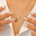Dettaglio ravvicinato della collana con ciliegia e cuore dorata indossata da modella - Collana Stile Ciliegia (6289)