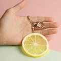 Realistic PVC lemon slice keychain with silver alloy lobster clasp held in hand - Large Lemon Slice
