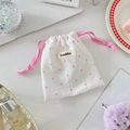 Dettaglio di un sacchetto in tessuto bianco con cuori rosa e etichetta tessuta - Cuore a strisce rosa
