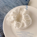 Green polka dot scrunchie with white lace trim on a white plate over denim fabric - Green Polka Dot