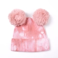 Gros plan du bonnet tricoté tie-dye rose et blanc avec deux pompons en fausse fourrure - Rose