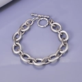 Detail eines klobigen Gliederkettenarmbands mit Spiralstruktur und silbernem Knebelverschluss - Silber
