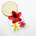 Three colorful frangipani flower hair clips in red, yellow, and pink on a display card - Mixed Color Set #20 (includes Cards)