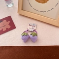 Detail of purple fabric strawberry hair tie with green leaves on a branded card - Purple