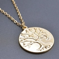 Macro shot of golden circular tree of life pendant with intricate embossed details - Gold Color + Necklace Chain