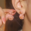Elegant rose gold snowflake drop earrings with sparkling pink rhinestones on model - Hermes Orange
